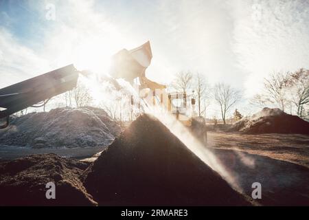 Des machines lourdes déplacent la terre et la biomasse dans les travaux de compost Banque D'Images