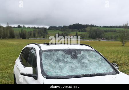 Bad Bayersoien, Allemagne. 27 août 2023. Après la tempête dans le quartier de Garmisch-Partenkirchen, le pare-brise d'une voiture a été détruit. En raison de graves dégâts causés par la tempête, le bureau de district de Garmisch-Partenkirchen a déclaré dimanche une situation catastrophique pour la ville, qui compte environ 1 300 habitants. 80 % des bâtiments de la ville seraient gravement endommagés. Crédit : Felix Hörhager/dpa/Alamy Live News Banque D'Images