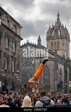 Royal Mile, Édimbourg, Écosse, Royaume-Uni. 27 août 2023. Bien que le Fringe Festival d'Édimbourg se termine le lundi 28 août, il n'y avait pas de sécurité ou de personnel Fringe autour de la High Street pour surveiller les foules et le temps des spectacles d'artistes de rue. Cependant, il y avait encore un large public congressant pour se divertir. Heromakro du Japon démontre son habileté d'équilibre. Crédit : Arch White/alamy Live News. Banque D'Images