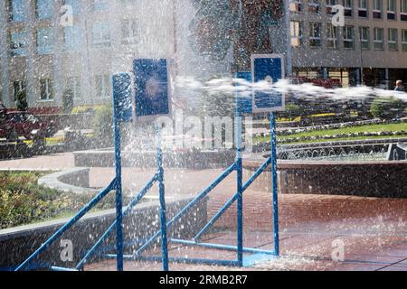 Un jet d'eau humide et puissant éclabousse et tire sur la cible, avec beaucoup de pression sur la rue à l'attraction, les compétitions. Banque D'Images