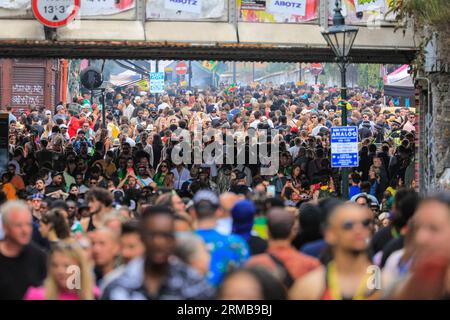 Londres, Royaume-Uni. 27 août 2023. La foule sur Ladbroke Grove. Les gens se pressent dans les rues autour de la route du carnaval et des systèmes de sonorisation, conduisant à la congestion dans de nombreux endroits. Jusqu'à deux millions de personnes sont attendues pour célébrer le carnaval ce week-end de fête de la Banque en participant ou en regardant le long de la route du carnaval, dans les systèmes sonores, les stands et les lieux. Poudres et peintures colorées, en reconnaissance de la tradition caribéenne et début des festivités du Carnaval de Notting Hill. Crédit : Imageplotter/Alamy Live News Banque D'Images