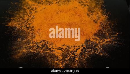Curcuma, curcuma longa, poudre tombant sur fond noir, épices indiennes Banque D'Images