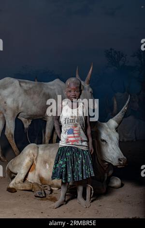 Petite fille Mundari avec des vaches dans le camp de Mundari la nuit Banque D'Images