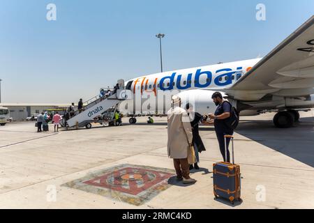 Passagers embarquant dans les escaliers aériens pour FlyDubai Aircraft à l'aéroport de Dubaï, Émirats arabes Unis Banque D'Images