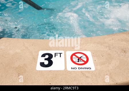 Bord de la piscine avec panneau d'avertissement No Diving et marqueur de profondeur de 3 pieds Banque D'Images