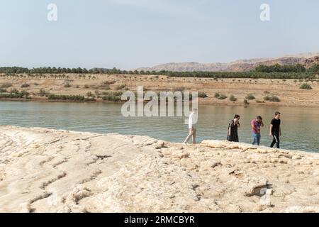 Touristes aux roches salées sttraction touristique sur le rivage de la mer Morte en Jordanie Banque D'Images