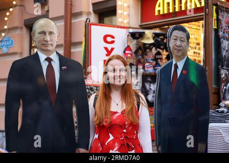 Photo touristique de femme avec des affiches dures de Vladimir Poutine et Xi Jinping sur la rue Novy Arbat, voyage en Russie Banque D'Images
