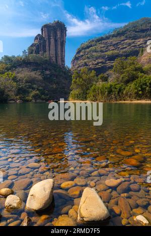 Une rive rocheuse sur la rivière Nine Bend ou Jiuxi à Wuyishan ou la région pittoresque du mont wuyi à Wuyi en Chine dans la province de fujian. Ciel bleu profond, image verticale Banque D'Images