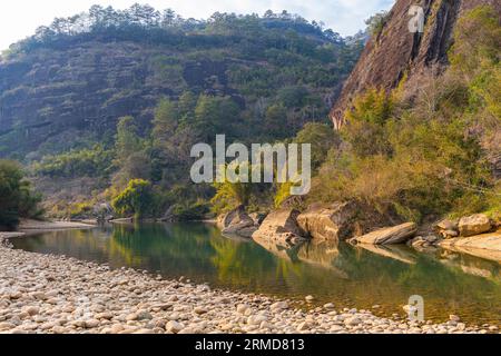 L'eau verte émeraude de la rivière Nine Bend ou de la rivière Jiuxi à travers Wuyishan ou le mont wuyi région pittoresque dans la province de Fujian en Chine. Arrière-plan du coucher du soleil Banque D'Images