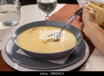 Bowl with tasty traditional Romanian tripe soup served on restaurant table Stock Photo