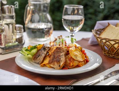 Veal medallions with roasted vegetables serving on the restaurant table Stock Photo