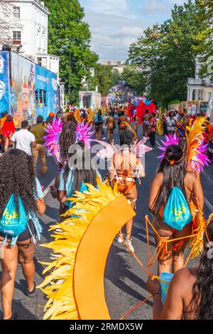 Notting Hill, Londres, Royaume-Uni. 28 août 2023. Le plus grand festival de rue d’Europe aura lieu plus tard dans les rues de Notting Hill. Des danseurs exotiques et des groupes musicaux jamaïcains défileront dans les rues, avec de la nourriture et des divertissements de rue autour de la région ajoutant à l'événement. Le Grand Parade a lieu le lundi du jour férié comme point culminant du festival de trois jours qui a commencé en 1966. Les participants se rassemblent à proximité et préparent leurs costumes colorés. Les femmes en costume marchant dans Ladbroke Grove vers le début de la parade Banque D'Images