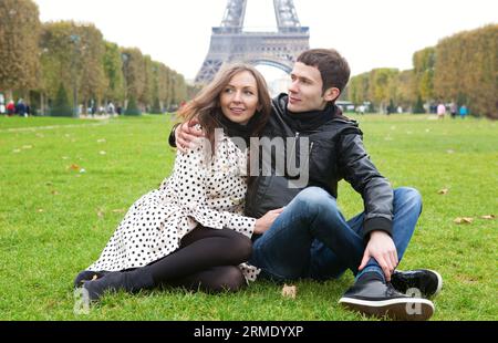 Jeune couple romantique assis près de la tour Eiffel Banque D'Images