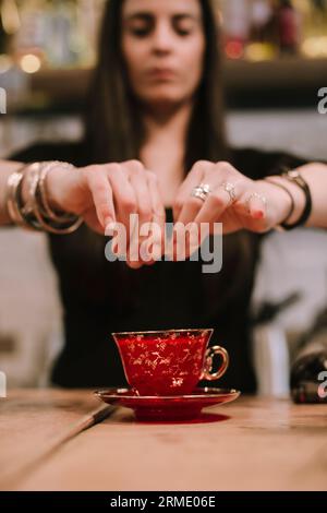 La jeune barwoman prépare un cocktail alcoolisé au bar Banque D'Images