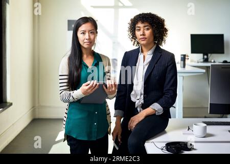 Portrait de collègues femmes confiantes contre le mur dans le bureau Banque D'Images