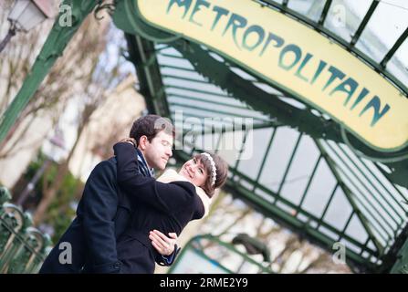 Couple s'embrassant sous le panneau du métro à Paris Banque D'Images