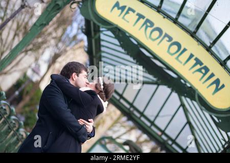 Couple s'embrassant sous le panneau du métro à Paris Banque D'Images