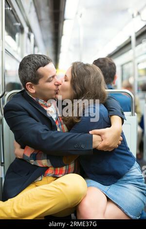 Couple s'embrassant dans le métro parisien Banque D'Images