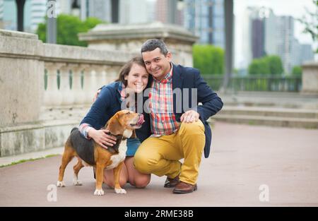 Couple marchant avec un chien dans une ville Banque D'Images
