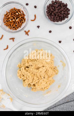 Pâte à biscuits dans un bol avec bretzels et pépites de chocolat flatlay Banque D'Images