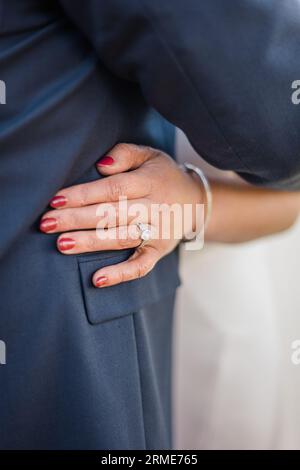 La main et la bague de la mariée brillent dans une étreinte de mariage émotionnelle Banque D'Images