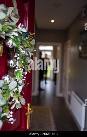 couronne de noël orne la porte rouge avec charme festif Banque D'Images