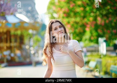 Belle jeune femme à Paris, près de la tour Eiffel par une belle et ensoleillée journée de printemps Banque D'Images