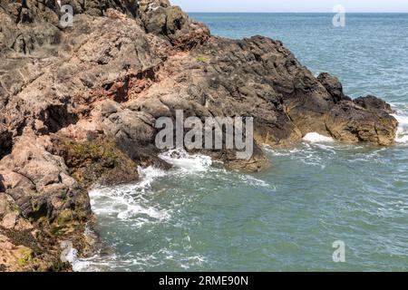 Bandes rouges de roche latérite, dépôts de fer de végétation brûlée entre deux coulées de lave, le chemin de falaise de Gobbins, Islandmagee, comté d'Antrim, nord Banque D'Images