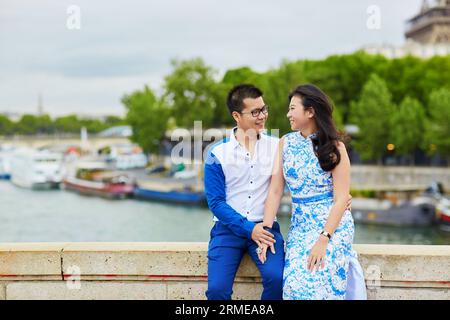 Jeune couple asiatique romantique embrassant sur le remblai de Seine à Paris, France Banque D'Images