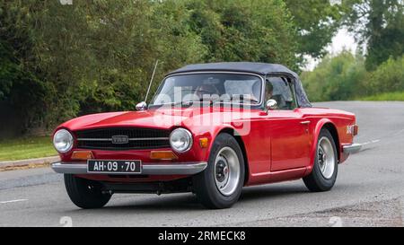 Whittlebury,Northants,UK -26 août 2023 : voiture rouge Triumph TR6 voyageant sur une route de campagne anglaise Banque D'Images