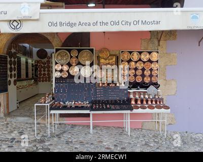 Magasin de vaisselle en cuivre dans une rue pavée dans la vieille ville site unesco dans la ville de Mostar un matin d'été, Bosnie-Herzégovine, 28 août 2023. Banque D'Images