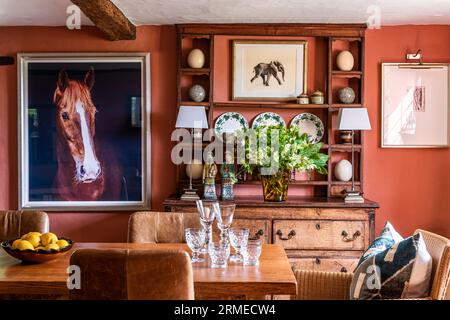 Ornements sur les étagères avec une grande impression de cheval par ami Roberstson dans la salle à manger 'Red Earth' de Tudor Farm, Surrey, Royaume-Uni Banque D'Images