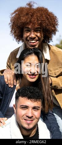 Gros plan de trois jeunes heureux souriants et l'air détendus dans la rue. Groupe de la génération y regardant l'espoir de la caméra souriant ensemble. Banque D'Images