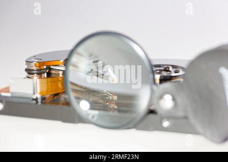 disque dur et loupe, représentant le processus de recherche de données, vue technique de la sauvegarde des données Banque D'Images