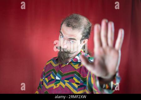 Hipster homme avec moustache disant non ou Stop et regardant la caméra avec la main ouverte Banque D'Images