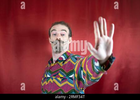 Hipster homme avec moustache disant non ou Stop et regardant la caméra avec la main ouverte Banque D'Images