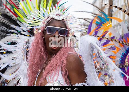 Notting Hill, Londres, Royaume-Uni. 28 août 2023. Le plus grand festival de rue d’Europe se déroule dans les rues de Notting Hill. Des danseurs exotiques et des groupes musicaux sur le thème jamaïcain défilent dans les rues, avec de la nourriture et des divertissements de rue autour de la région ajoutant à l'événement. Le Grand Parade a lieu le lundi du jour férié comme point culminant du festival de trois jours, qui a commencé en 1966. Femme en costume élaboré Banque D'Images