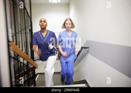 Femmes médecins marchant ensemble à l'escalier Banque D'Images