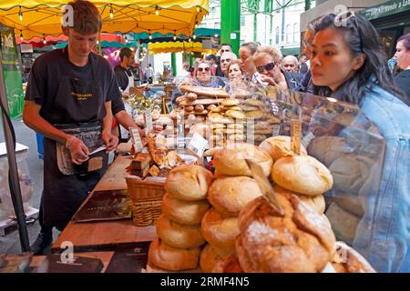 Les gens achètent des pains, des gâteaux, des pâtisseries, des pâtisseries sur le stand du marché Olivier's Bakery Borough Market dans le sud de Londres Angleterre KATHY DEWITT Banque D'Images