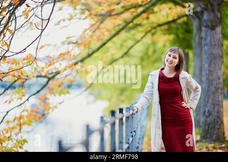 Belle jeune femme à Paris marchant dans le parc par un jour lumineux d'automne. Tourisme et vacances en France à la saison d'automne Banque D'Images