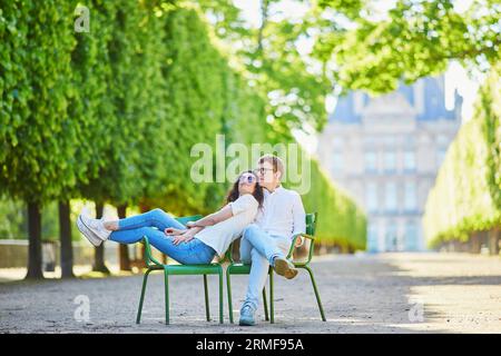 Heureux couple romantique à Paris, assis sur des chaises traditionnelles en métal vert dans le jardin des Tuileries. Touristes passant leurs vacances en France Banque D'Images