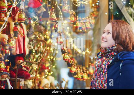 Jeune fille regardant les vitrines décorées pour Noël Banque D'Images