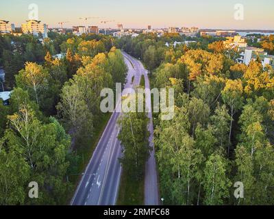 Vue aérienne de la route asphaltée à travers la forêt près d'Espoo, banlieue résidentielle d'Helsinki, Finlande Banque D'Images