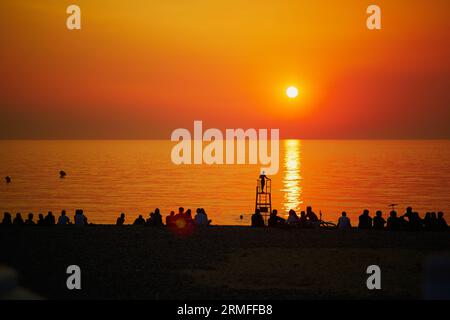 Les gens profitent du coucher de soleil sur la plage de Mers-les-bains, petite station balnéaire et village de pêcheurs à la frontière de la Picardie et de la Normandie dans le Nord FRA Banque D'Images