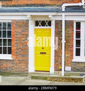 Maison typique à Londres avec des murs de briques rouges et porte jaune vif Banque D'Images