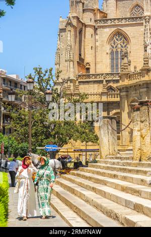 Touristes marchant par l'escalier de l'Archivo General de Indias, avec le côté sud de la cathédrale de Séville. Séville, Andalousie, Espagne. Banque D'Images