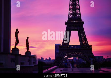 Vue panoramique sur la tour Eiffel avec un ciel rose et violet spectaculaire au lever du soleil. Photo prise depuis la plate-forme d'observation du Trocadéro à Paris, France Banque D'Images