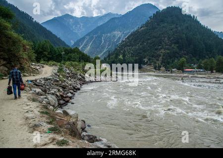 Keran Kupwara, Inde. 25 août 2023. Vue générale du fleuve Neelam ou Kishan Ganga qui a divisé le Cachemire en deux parties contrôlées par les rivaux nucléaires Inde et Pakistan. La rivière agit comme une ligne de contrôle contestée et coule à travers un village appelé Keran des deux côtés qui est situé sur le côté nord du district frontalier du Cachemire indien Kupwara à environ 150 km de Srinagar et 93 km de Muzaffarabad, dans la partie pakistanaise du Cachemire. (Photo de Faisal Bashir/SOPA Images/Sipa USA) crédit : SIPA USA/Alamy Live News Banque D'Images