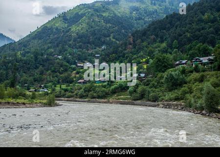 Keran Kupwara, Inde. 25 août 2023. Vue générale du fleuve Neelam ou Kishan Ganga qui a divisé le Cachemire en deux parties contrôlées par les rivaux nucléaires Inde et Pakistan. La rivière agit comme une ligne de contrôle contestée et coule à travers un village appelé Keran des deux côtés qui est situé sur le côté nord du district frontalier du Cachemire indien Kupwara à environ 150 km de Srinagar et 93 km de Muzaffarabad, dans la partie pakistanaise du Cachemire. Crédit : SOPA Images Limited/Alamy Live News Banque D'Images