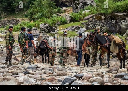 Keran Kupwara, Inde. 25 août 2023. Des soldats de l’armée indienne vus avec leurs chevaux alors qu’ils se préparent à se diriger vers leurs bunkers, à la rivière Neelam ou au Kishan Ganga qui a divisé le Cachemire en deux parties contrôlées par les rivaux nucléaires Inde et Pakistan. La rivière agit comme une ligne de contrôle contestée et coule à travers un village appelé Keran des deux côtés qui est situé sur le côté nord du district frontalier du Cachemire indien Kupwara à environ 150 km de Srinagar et 93 km de Muzaffarabad, dans la partie pakistanaise du Cachemire. Crédit : SOPA Images Limited/Alamy Live News Banque D'Images